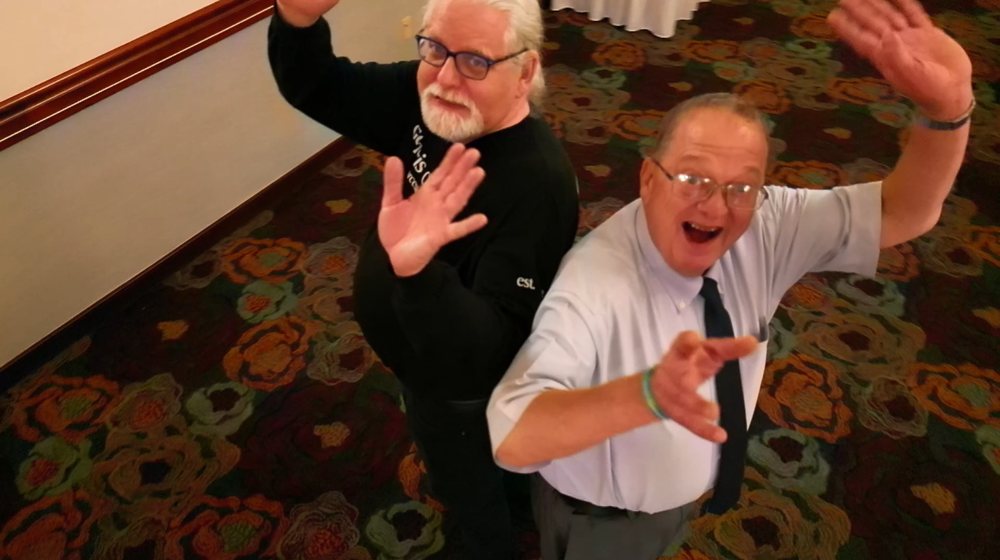 Two event guests looking up and reaching toward the drone camera during a Spin It. experience